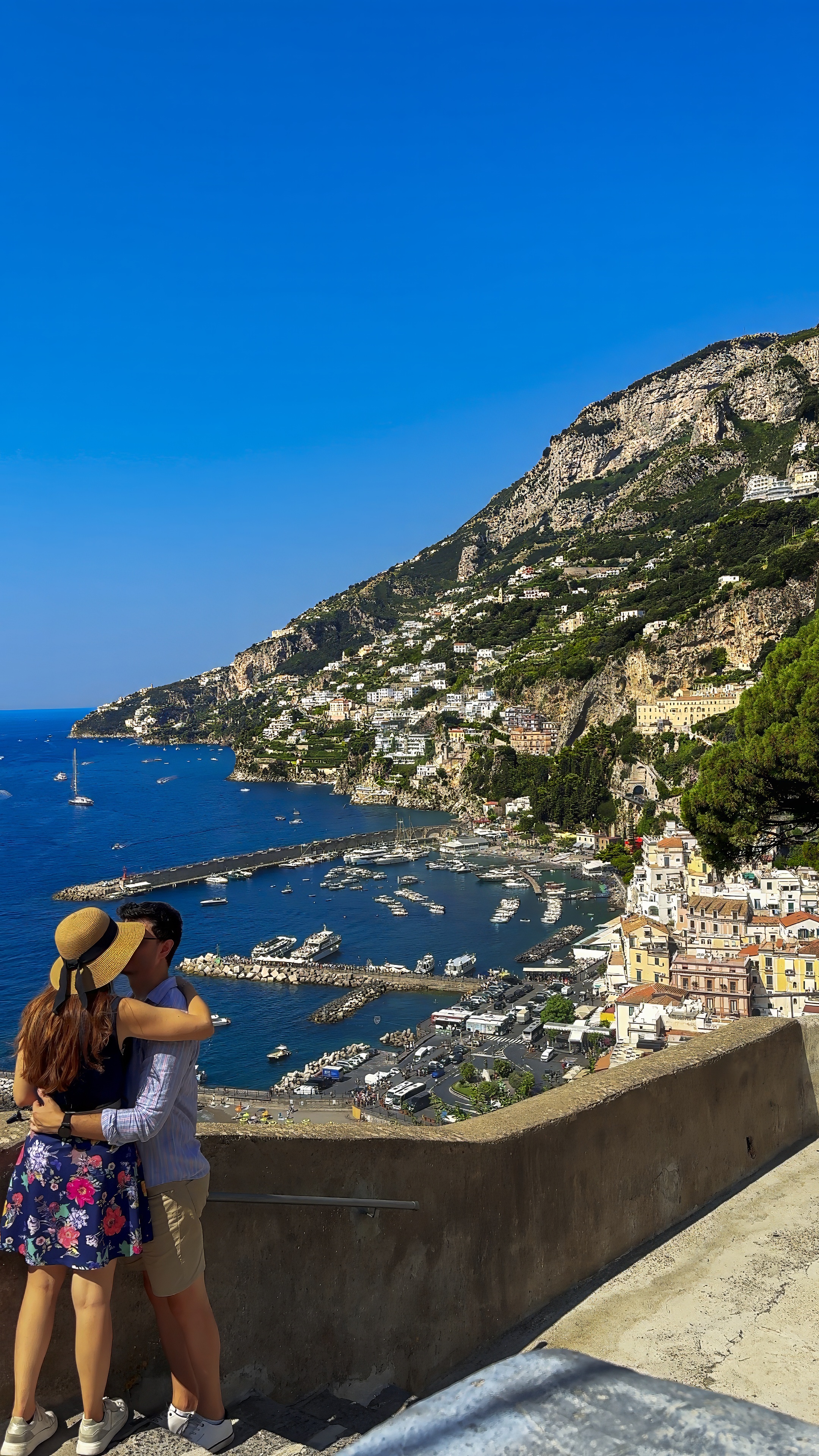 Davide and Barbara on a terrace above Amalfi, with the town and harbour below.
