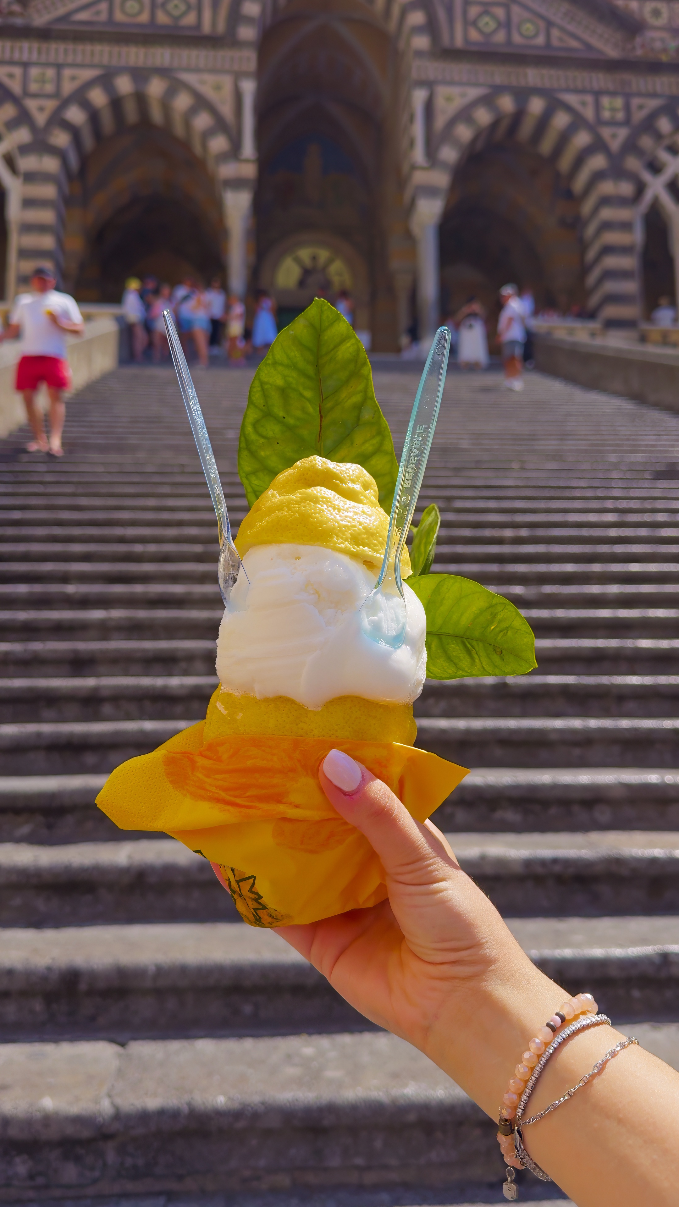 A lemon sorbet served in the fruit, held up in front of the cathedral steps.