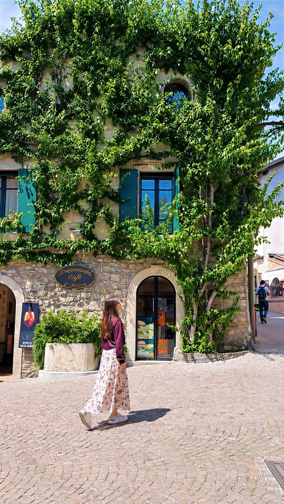Barbara standing in front of a house whose façade is covered in ivy.