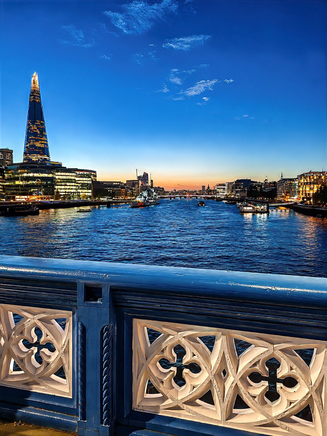 The Shard and the river at sunset, seen past a carved stone balustrade.