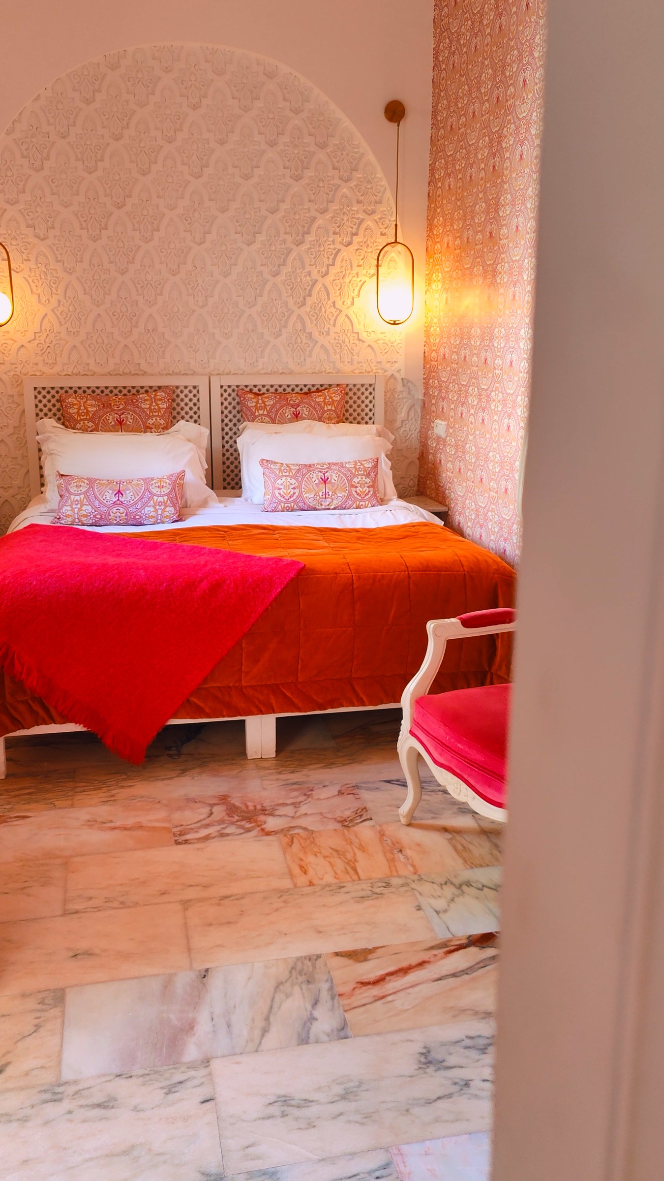 Our room: a bed with a carved wooden headboard and red bedding