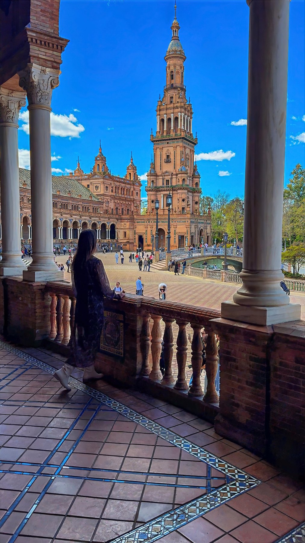 Barbara in the arcaded gallery of the Plaza de España, with one of its towers beyond