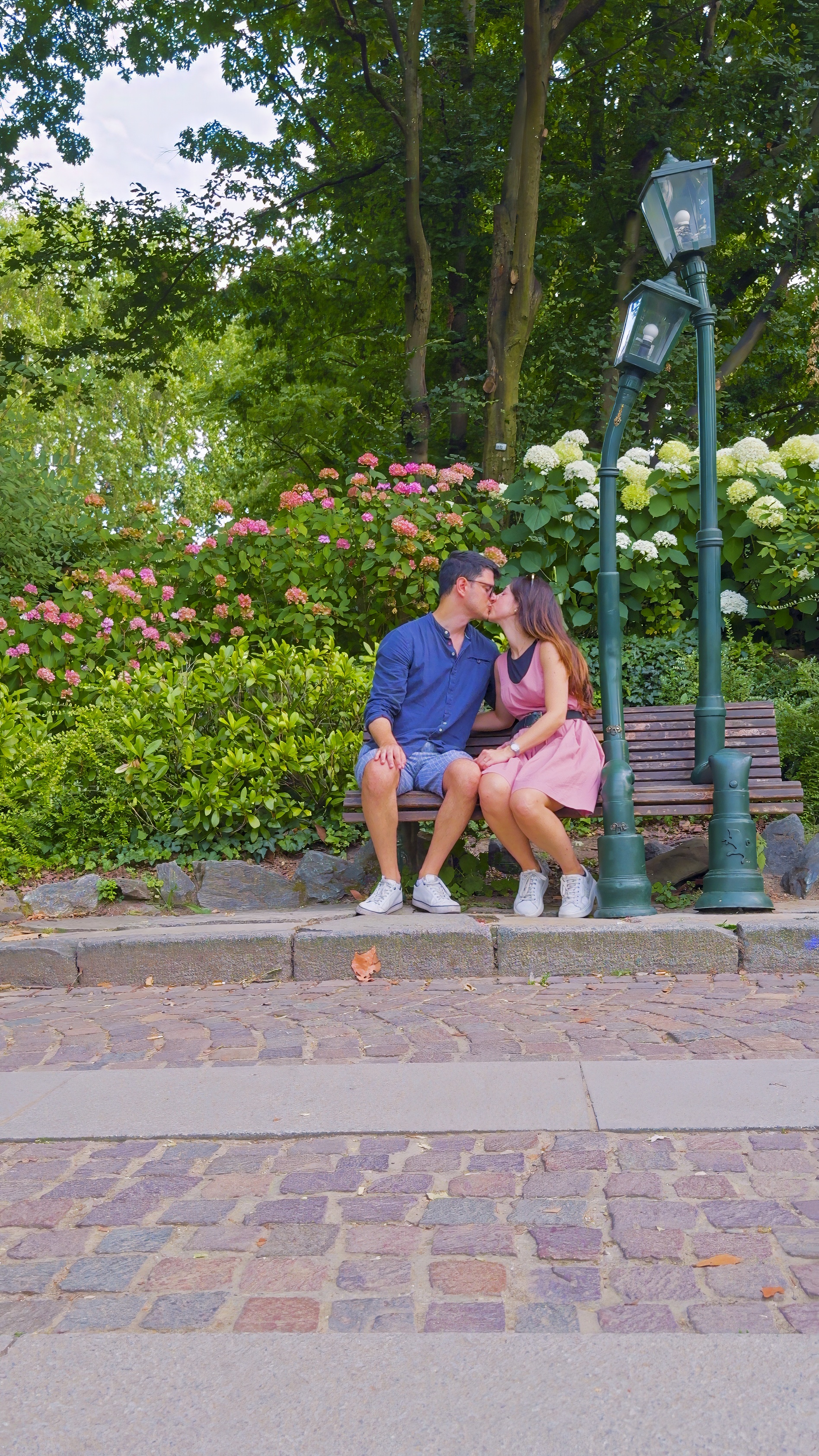 Barbara and Davide on a garden bench among hydrangeas.